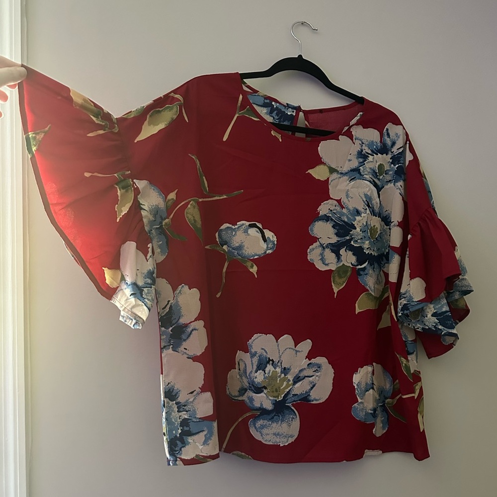 Red floral lightweight blouse. Flowy sleeves and button collar back.